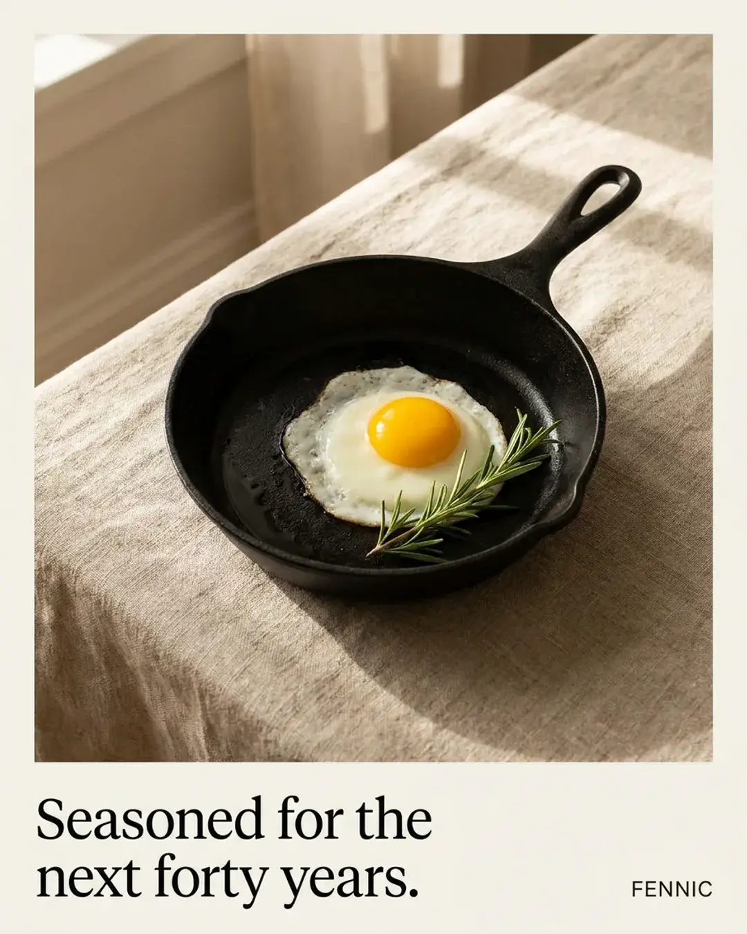 Static ad for a Fennic cast-iron skillet seen from above on linen, an egg frying, headline “Seasoned for the next forty years.”